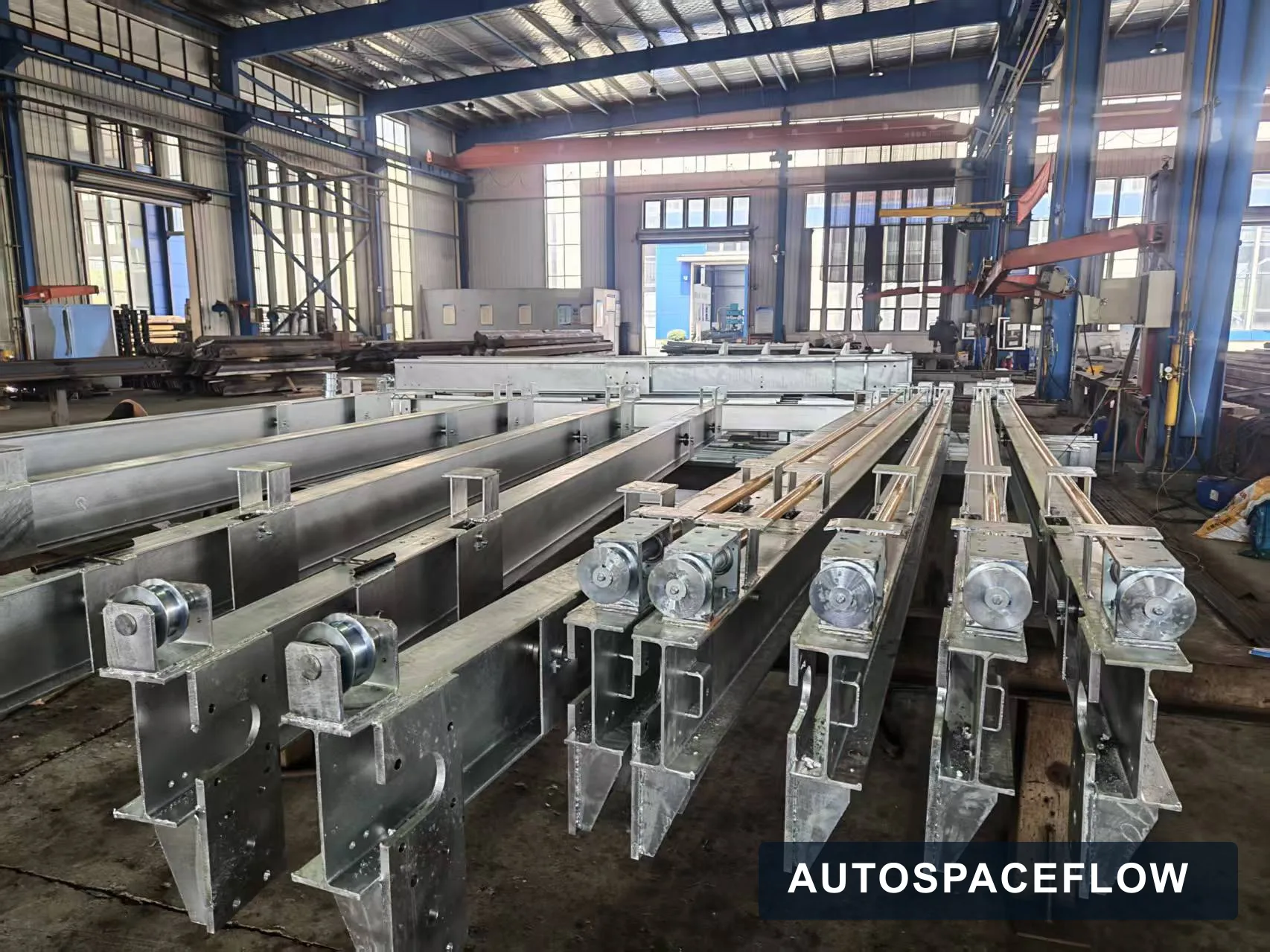 Galvanized parking system structural assemblies and roller components arranged on the AutoSpaceFlow factory floor