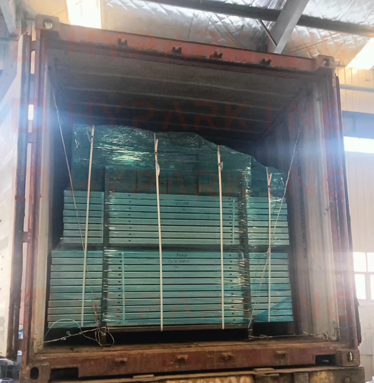 Powder-coated steel parking platforms stacked and strapped inside a shipping container for the Florida project