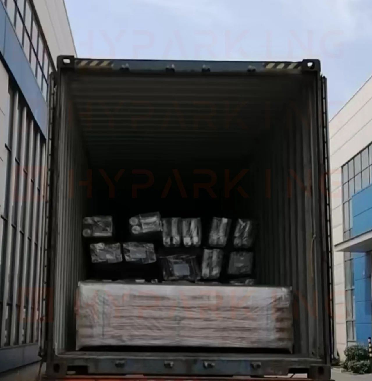 Crated hydraulic and control components loaded above platform sections in the container